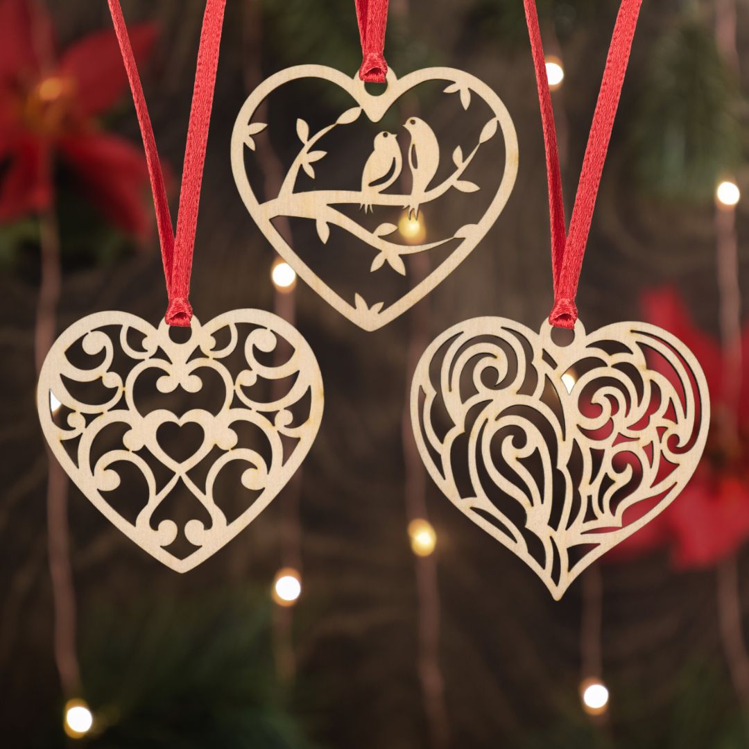 Heart-shaped decorative ornaments with intricate patterns hanging against a blurred festive background.