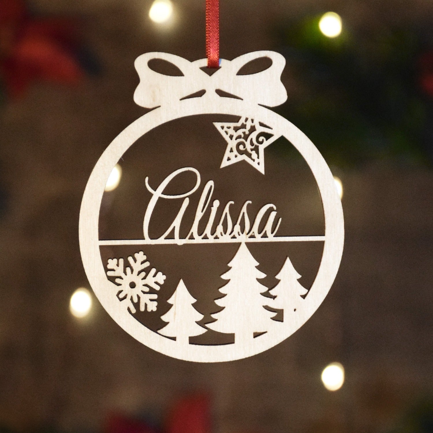 Laser cut christmas ornaments cut from baltic birch. This ornament has a tree shape and snowflakes.