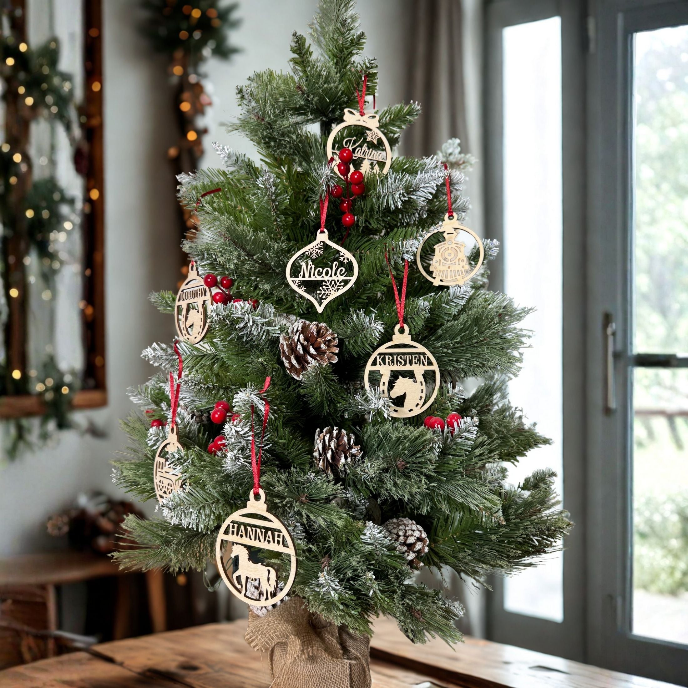 Decorated Christmas tree with gold ornaments on a wooden table. Personalized wood ornaments hang on the tree.