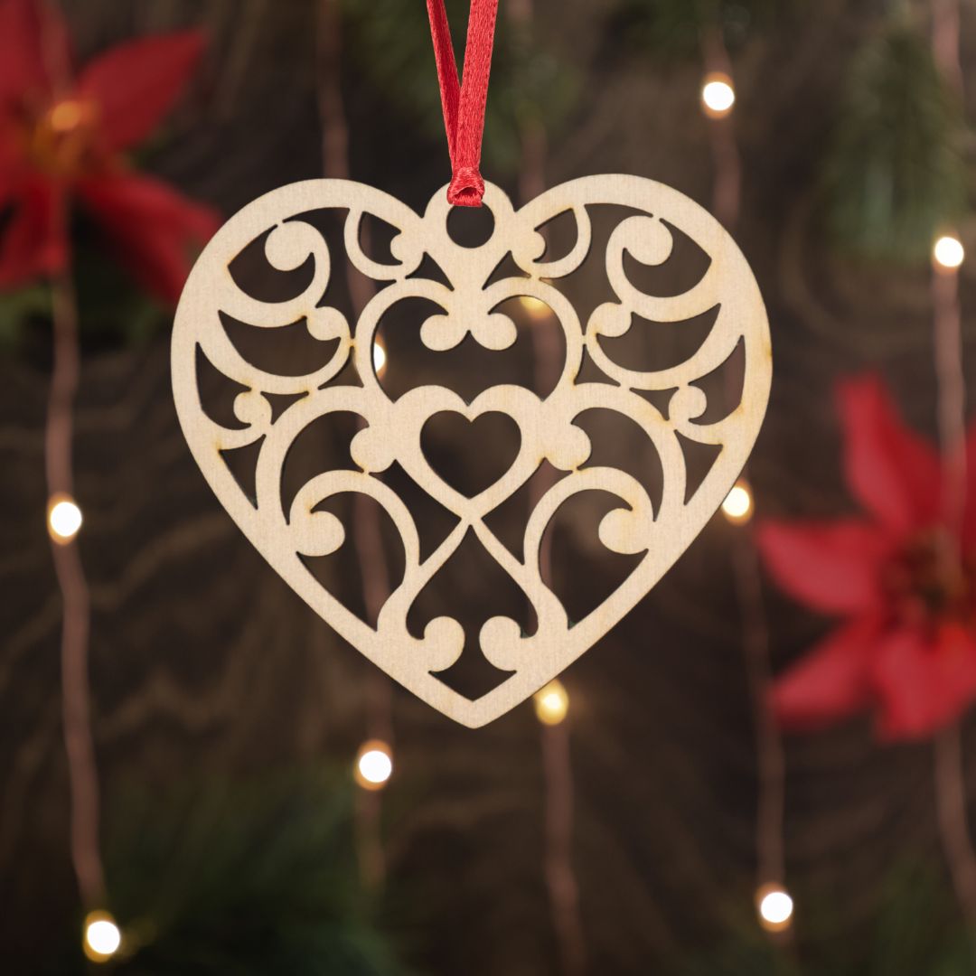 Decorative heart-shaped ornament hanging against a blurred background with lights and flowers.