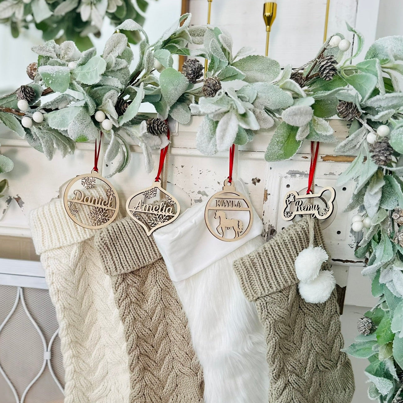 Knitted stockings with wooden tags hanging on a decorative wreath.